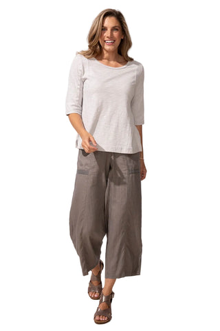 Woman wearing a light gray top and wide-leg pants on a white background