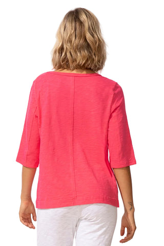 Person wearing a pink top and white pants on a white background