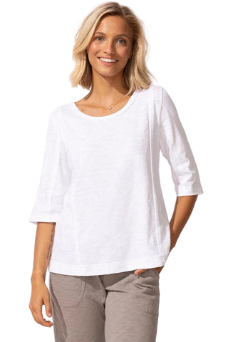 Woman wearing a white top and gray pants on a white background