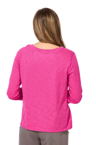 Person wearing a pink long-sleeve top against a white background