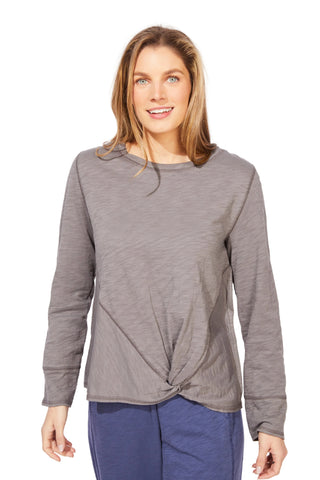 Woman wearing a gray long-sleeve top with a knot detail on a white background