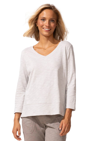 Woman wearing a light gray long-sleeve top on a white background