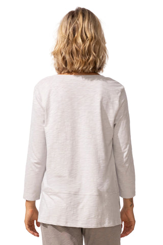 Person wearing a light gray long-sleeve top on a white background