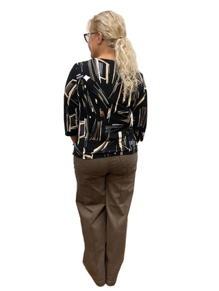 Person wearing a shiny black and silver jacket in a fitting room.