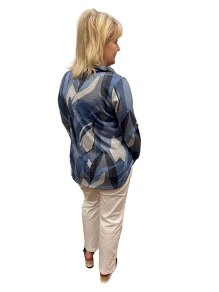 Person wearing a blue patterned jacket in a fitting room.