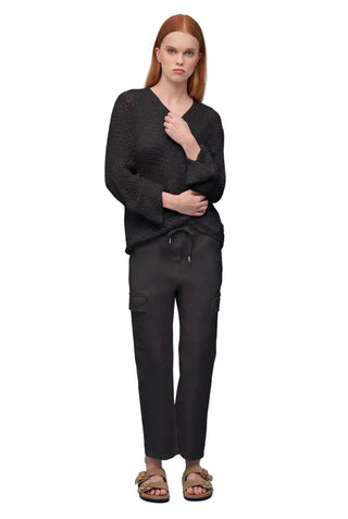 Woman wearing a black outfit against a light blue background