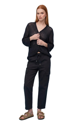 Woman wearing a black outfit against a light blue background