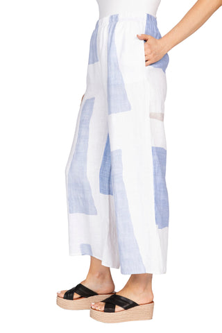 Person wearing a white and blue striped dress with black sandals on a white background