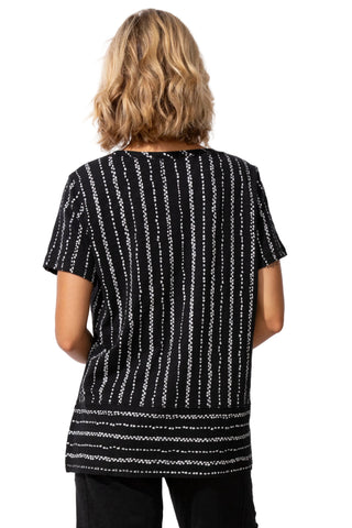 Person wearing a black and white patterned top on a white background