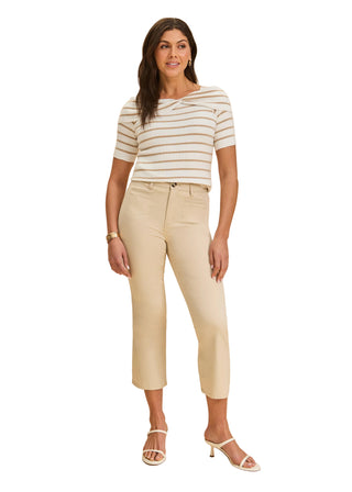 Woman wearing a striped shirt and beige pants against a beige background