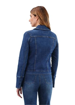 Woman wearing a blue denim jacket and jeans on a light gray background