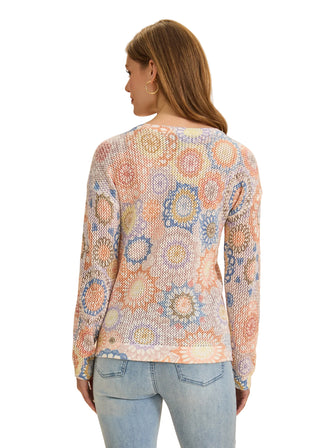 Woman wearing a patterned sweater and jeans on a beige background