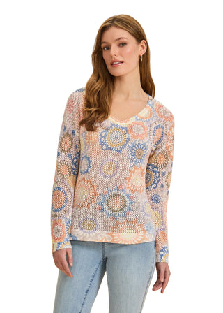 Woman wearing a patterned sweater and jeans on a beige background