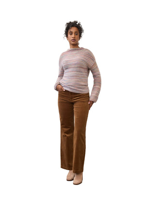 A model stands in a studio wearing a long-sleeve crewneck sweater with horizontal stripes in pink, blue, and beige, paired with brown corduroy pants and beige heels.