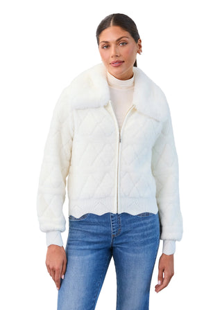 Woman wearing a white fur jacket and blue jeans on a light gray background