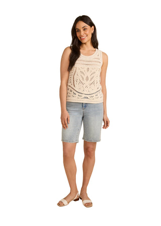 Woman wearing a sleeveless top and shorts on a beige background