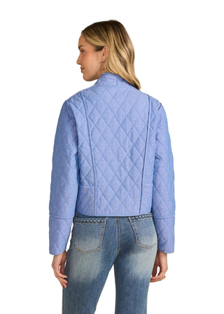 Person wearing a blue quilted jacket and jeans on a beige background