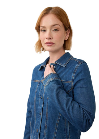 A woman with short auburn hair wearing a blue denim button-up shirt, posing against a neutral off-white background.