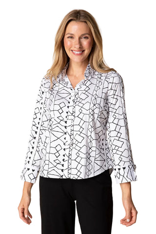 Woman wearing a white blouse with black geometric pattern on a beige background