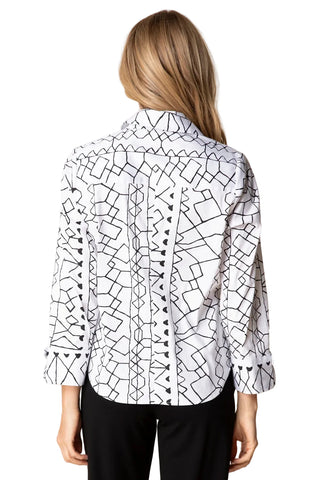 Person wearing a white shirt with black geometric pattern on a beige background