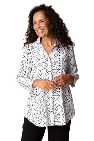 Woman wearing a white blouse with black geometric pattern against a beige background