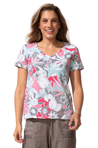 Woman wearing a floral patterned top on a plain background