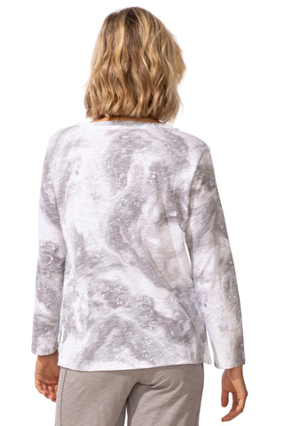 Person wearing a silver and white patterned top on a white background