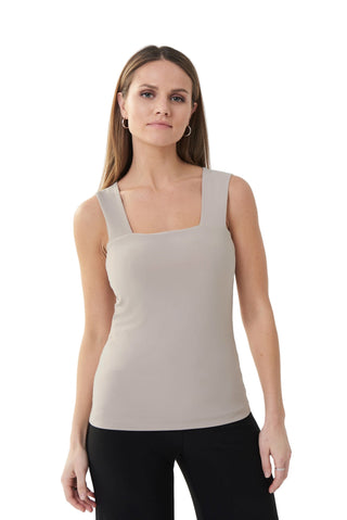 Woman wearing a beige tank top against a white background