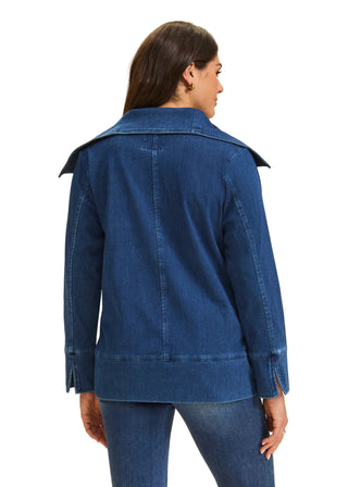 Woman wearing a blue denim jacket on a beige background