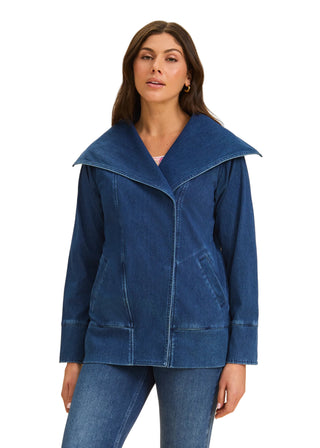 Woman wearing a blue denim jacket on a beige background