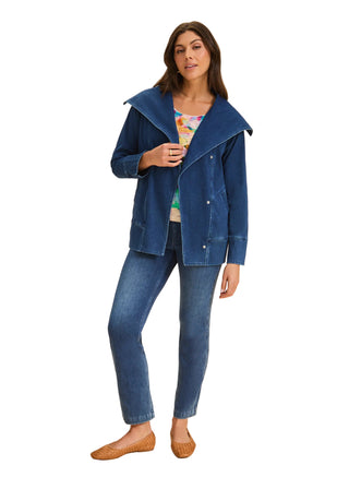 Woman wearing a blue jacket and jeans on a beige background