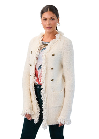 Woman wearing a cream cardigan with tassels on a white background
