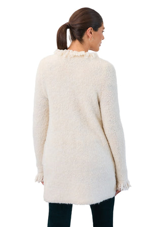 Woman wearing a cream-colored fluffy cardigan against a white background