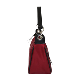 A red nylon shoulder bag with black leather trim and a black strap, featuring silver-tone metal hardware, shown against a light gray background.