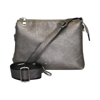 A metallic gray faux-leather crossbody bag with a top zipper, shown with an adjustable black webbing strap and silver buckle on a light gray background.