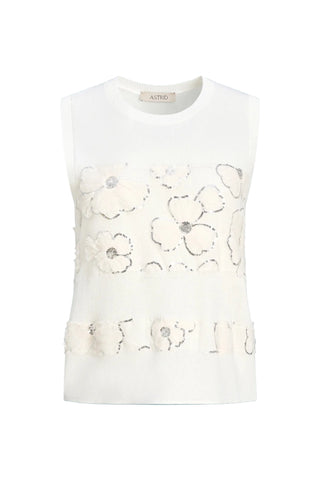 White sleeveless top with floral embellishments on a light blue background