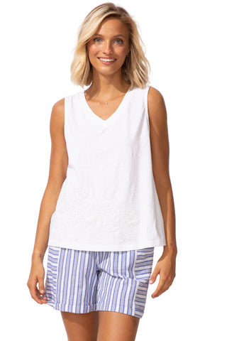 Woman wearing a white sleeveless top and striped shorts on a white background