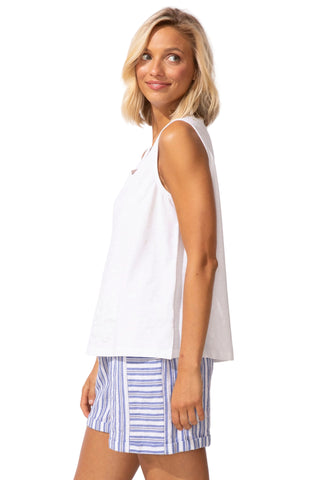Woman wearing a white sleeveless top and striped shorts on a white background