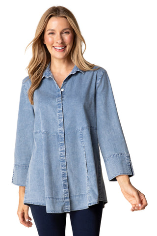 Woman wearing a blue denim shirt against a beige background