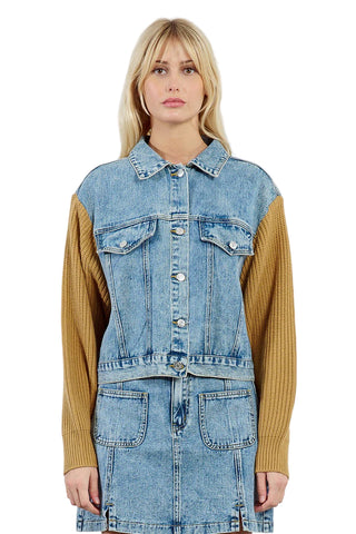 Woman wearing a denim jacket over a mustard yellow shirt on a white background