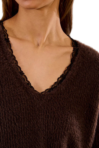 Close-up of a brown textured garment with a V-neckline.