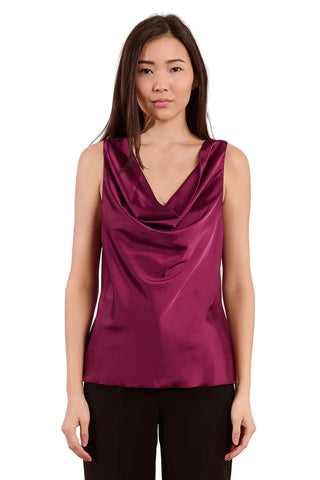 Woman wearing a purple sleeveless top against a pink background