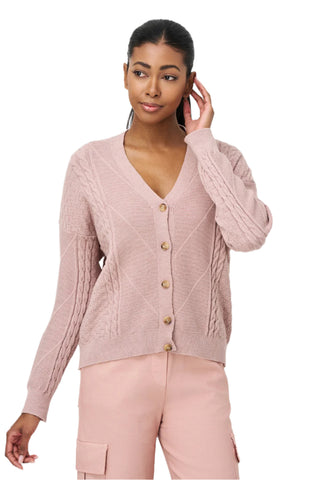 Woman wearing a pink cable knit cardigan with gold buttons on a white background