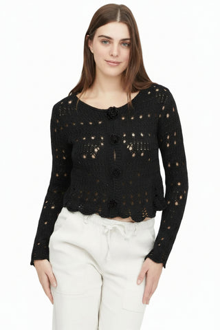 Woman wearing a beige crochet cardigan on a white background