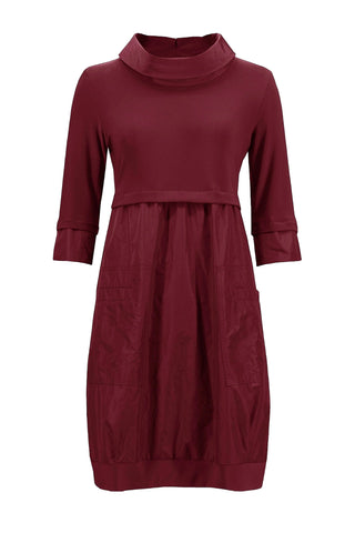 Maroon dress with a cowl neck on a light gray background