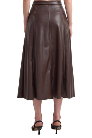 A dark brown faux-leather midi skirt with vertical seam detailing, shown on a model from the back against a plain white studio background.