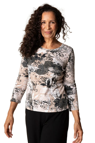 Woman wearing a floral patterned top against a plain background