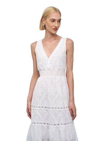 Woman wearing a white lace dress against a light blue background