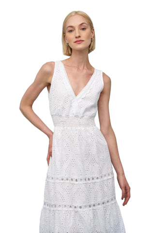 Woman wearing a white lace dress against a light blue background