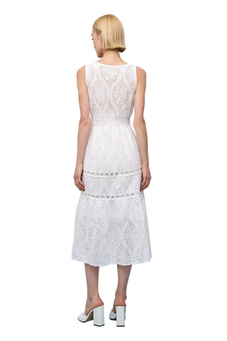 Woman wearing a white lace dress against a light blue background